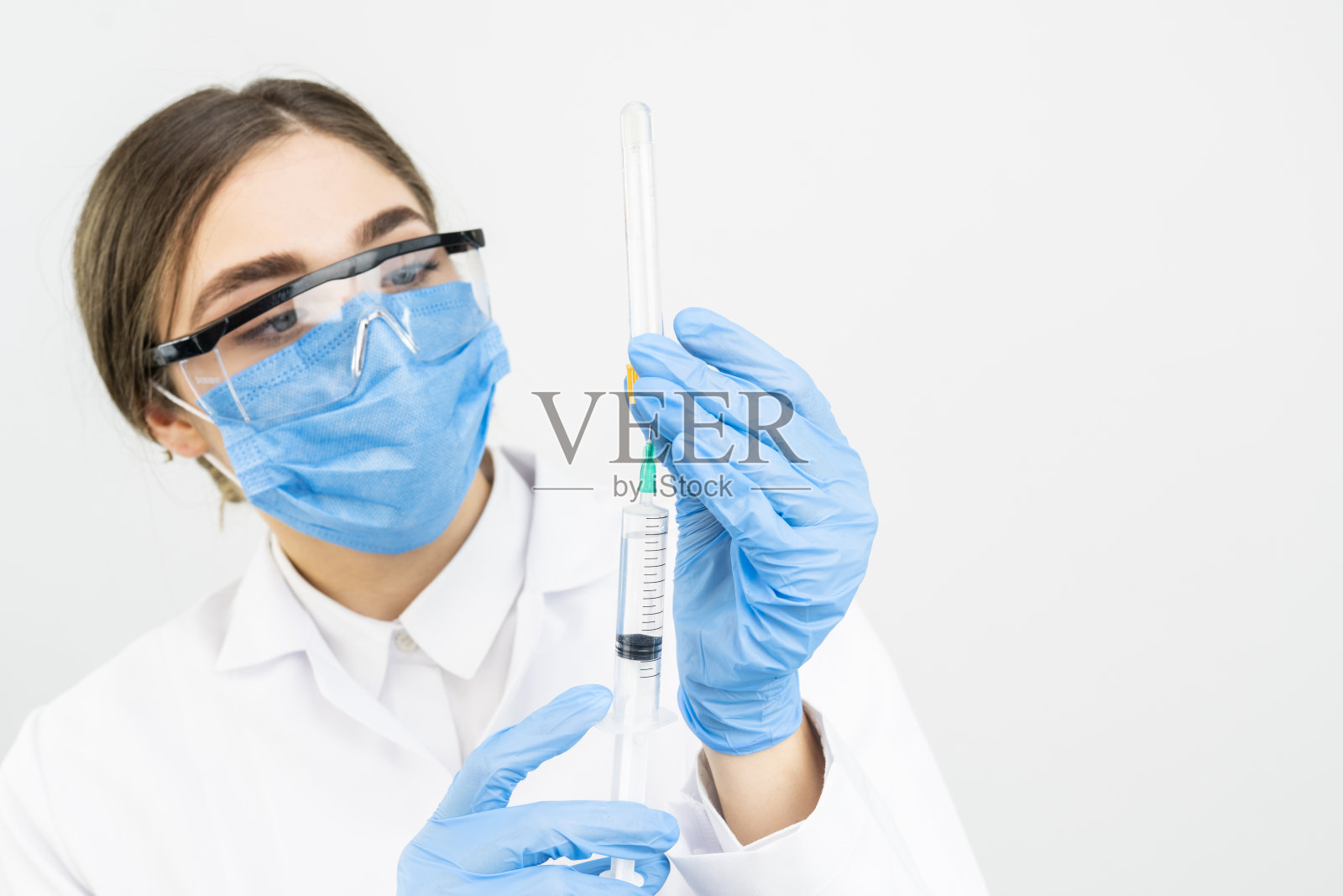 概念:对抗covid-19冠状病毒，医生或科学家在实验室拿着注射液体疫苗的注射器，概念:疾病、医疗、科学。照片摄影图片