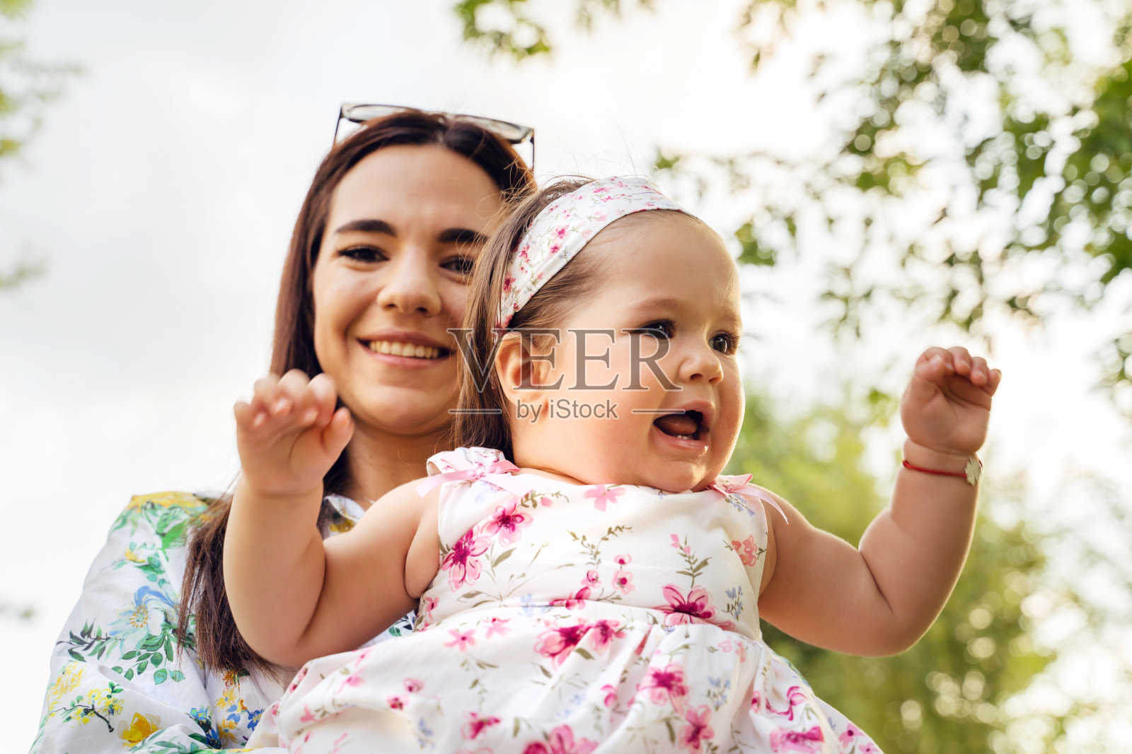 正面近距离观看快乐的母亲和宝贝女儿在夏日微笑，有乐趣-母亲和童年成长的单亲母亲的概念照片摄影图片