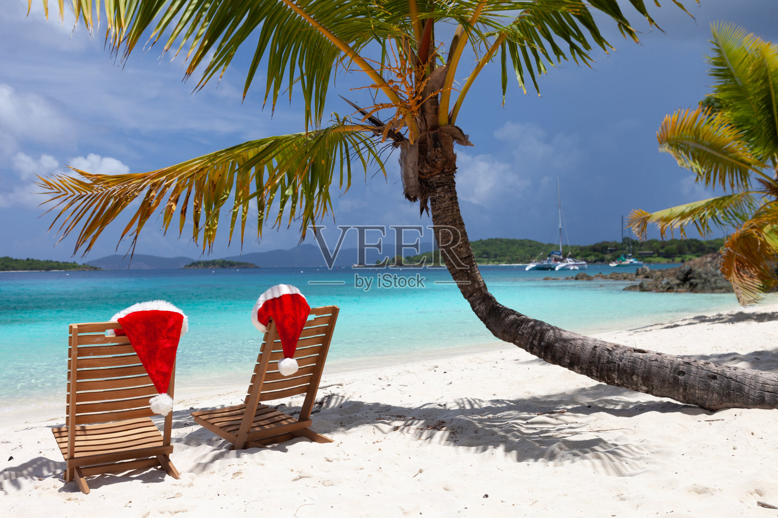 热带海滩上的沙滩椅和圣诞帽照片摄影图片