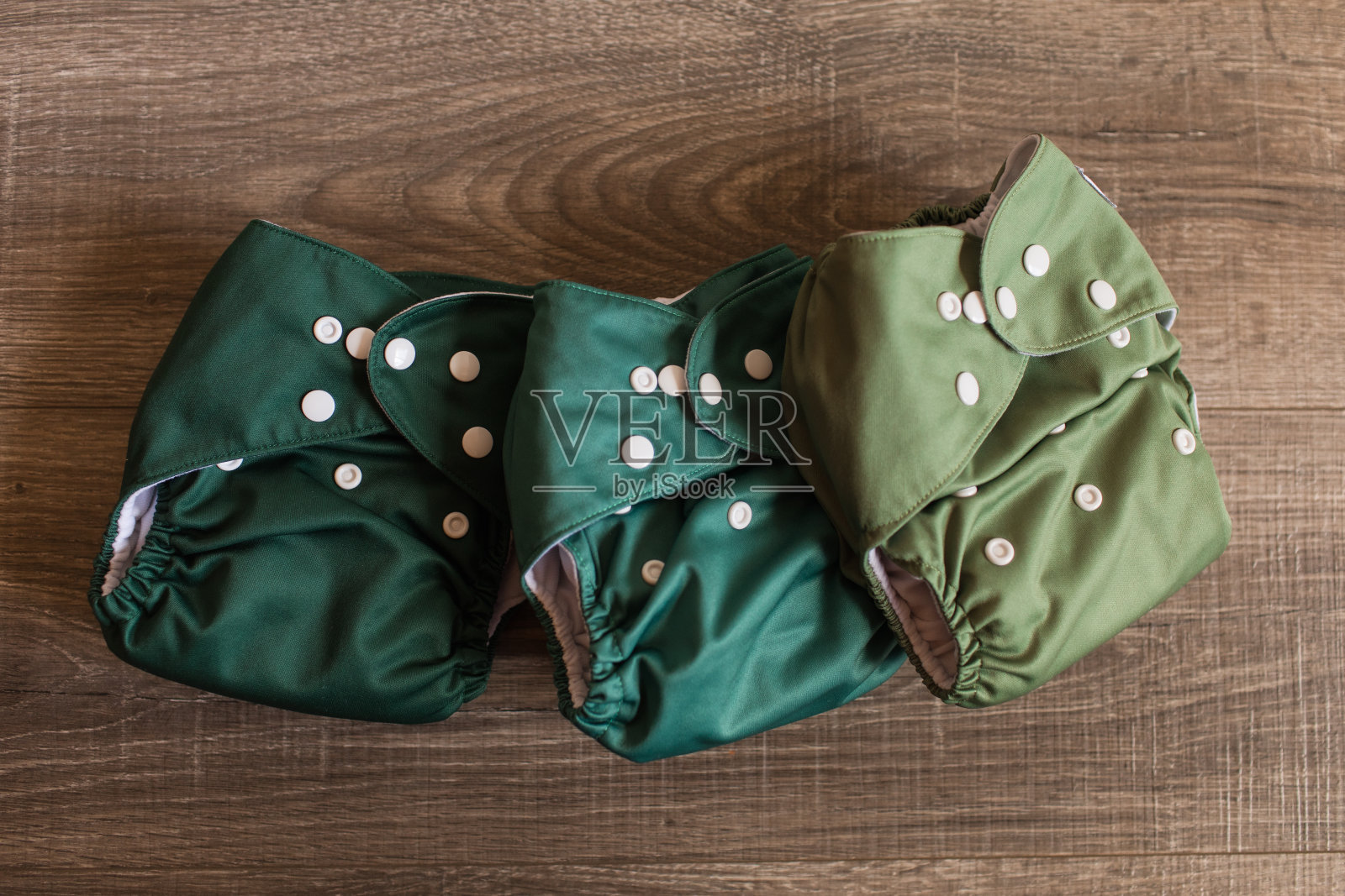 木地板上的绿色可重复使用布尿布照片摄影图片