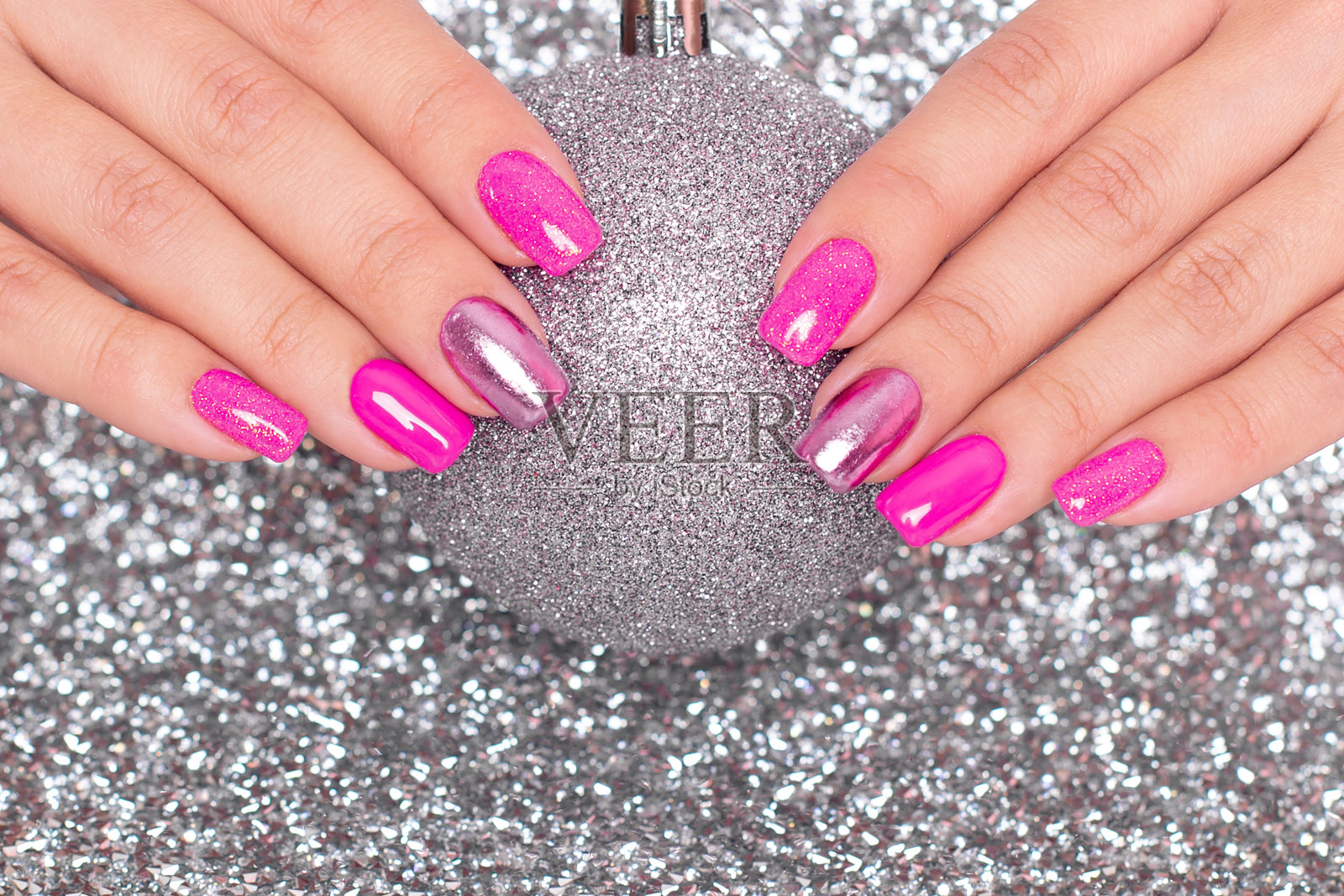 女性的手与节日美甲指甲拿着圣诞玩具照片摄影图片