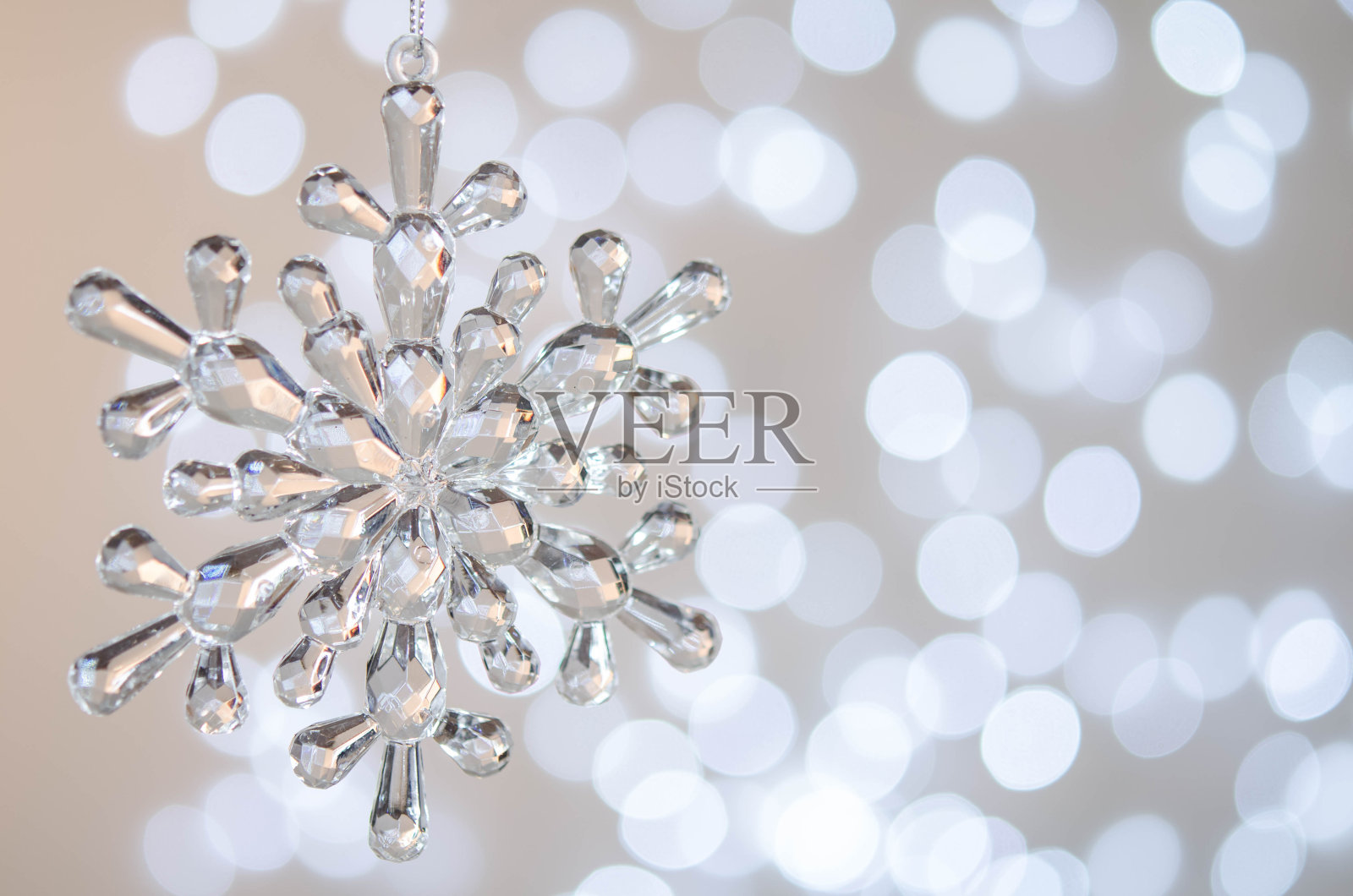 透明的玩具雪花。散景。银色的圣诞彩灯。照片摄影图片