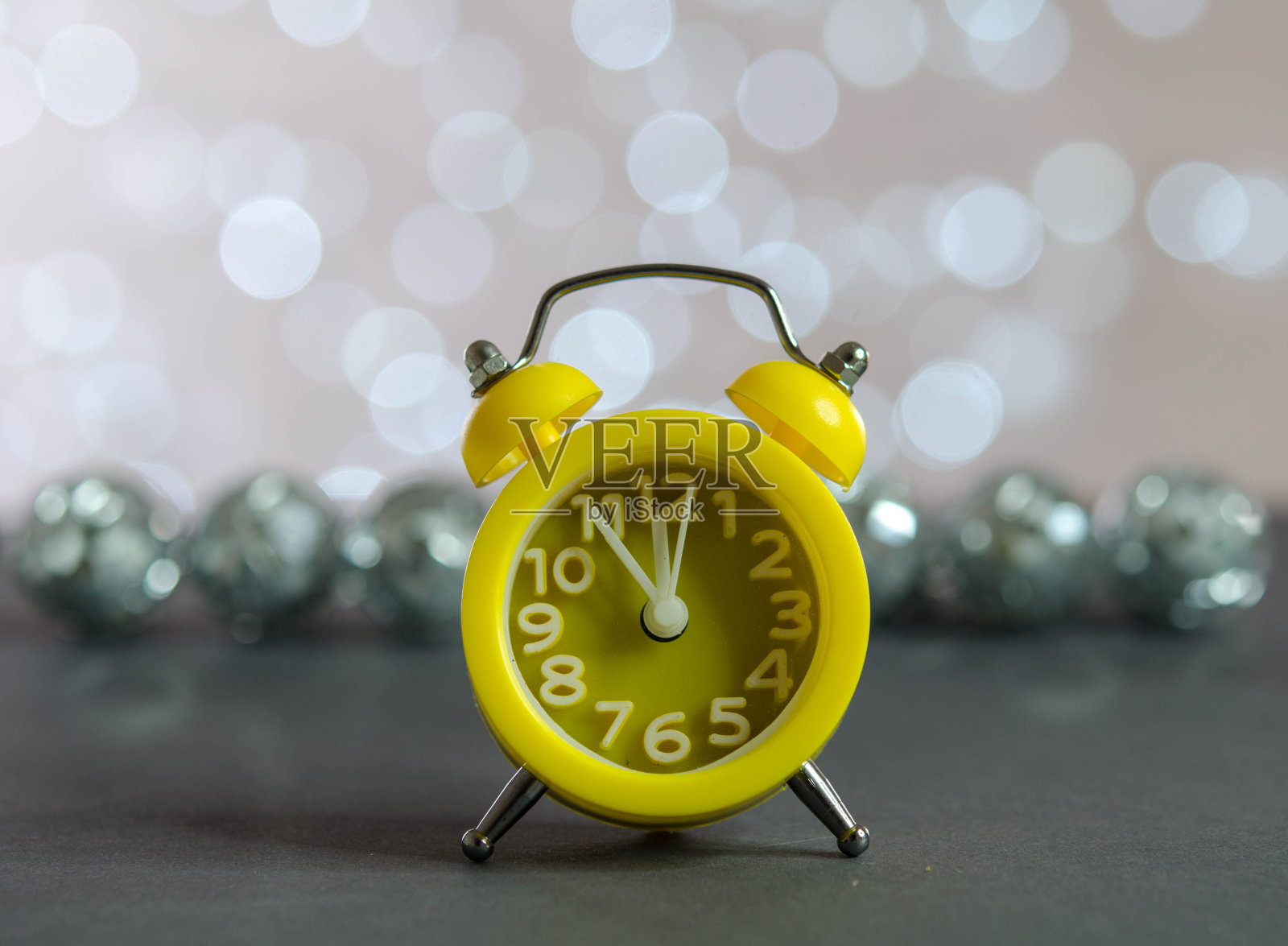 黄色的闹钟和镜子球放在桌子上。照片摄影图片