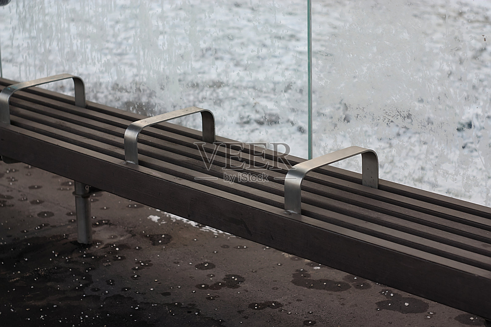 在一个冬天的早晨，坐在公交车站的长椅上照片摄影图片