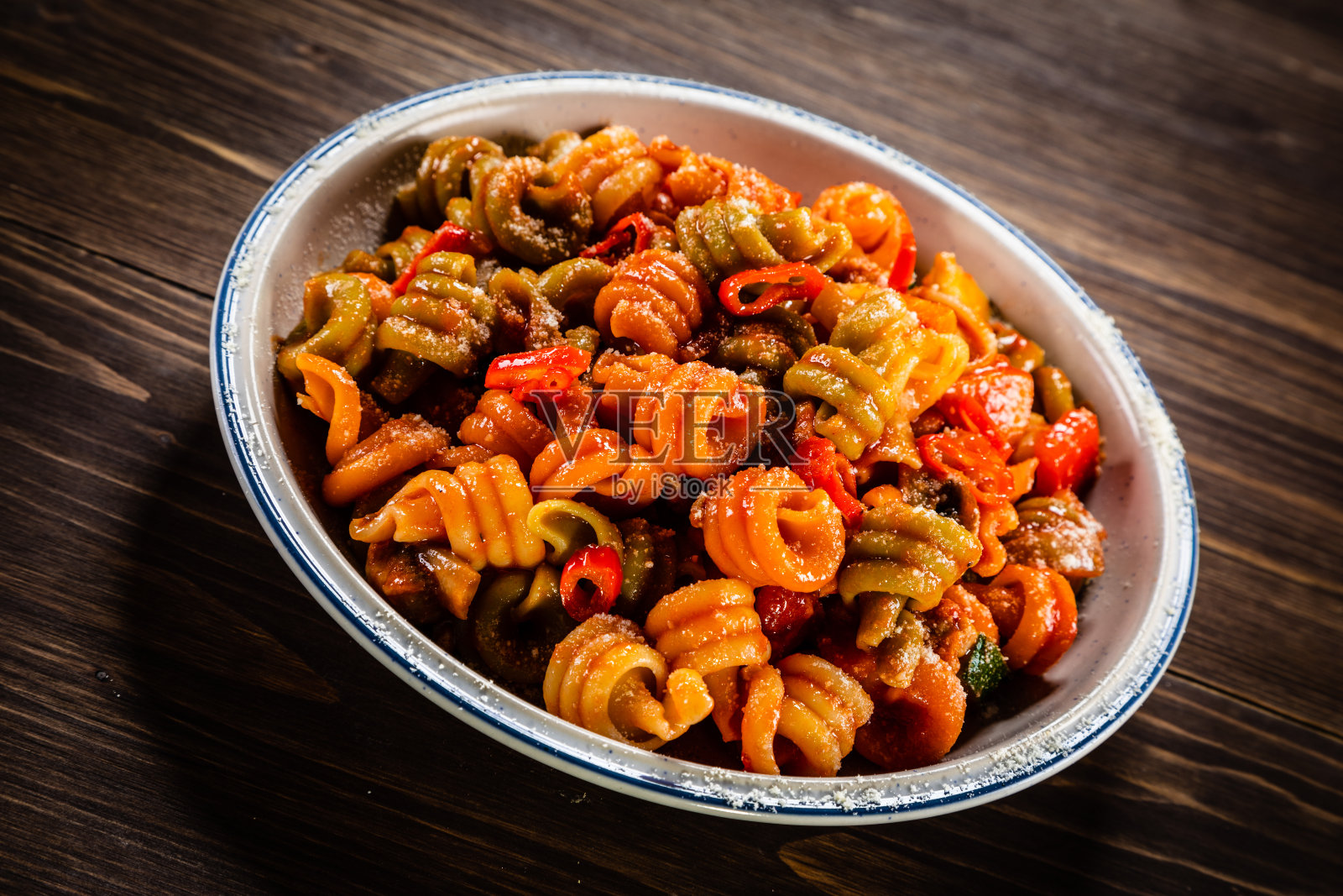 木桌上放有番茄酱、猪肉和帕尔马干酪的意大利面照片摄影图片