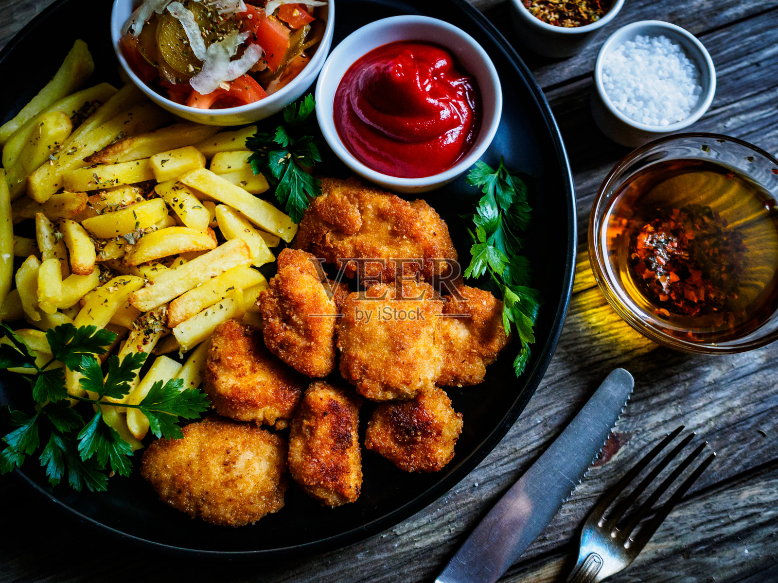 炸鸡块配薯条和蔬菜沙拉放在木桌上照片摄影图片