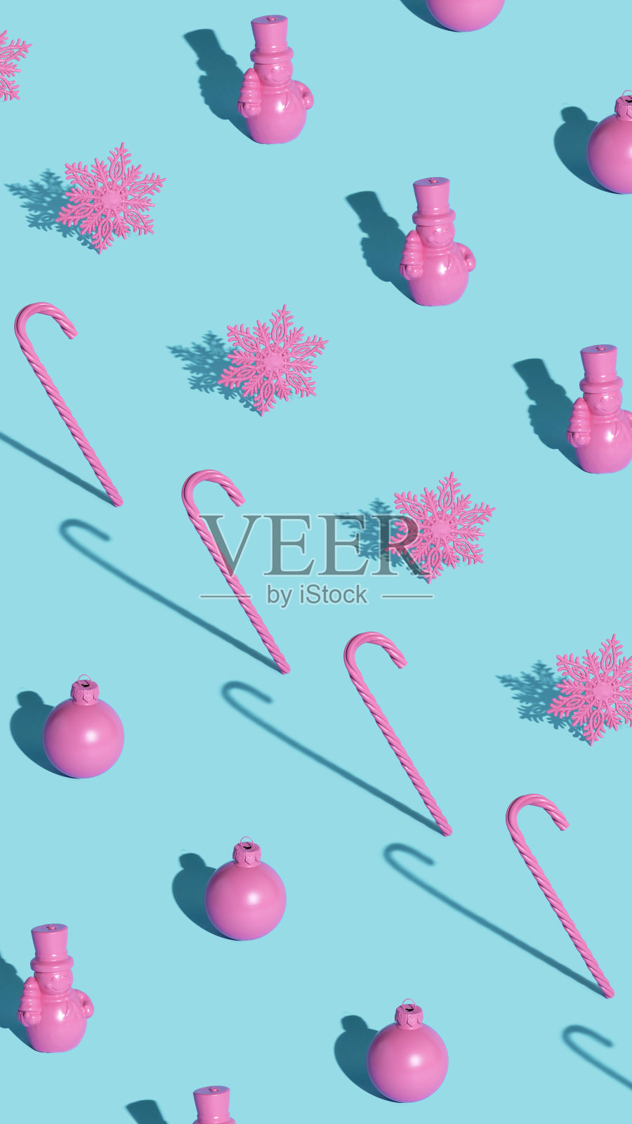 用粉红色的装饰品、糖果和雪花做成的现代圣诞图案，在柔和的蓝色背景上照片摄影图片