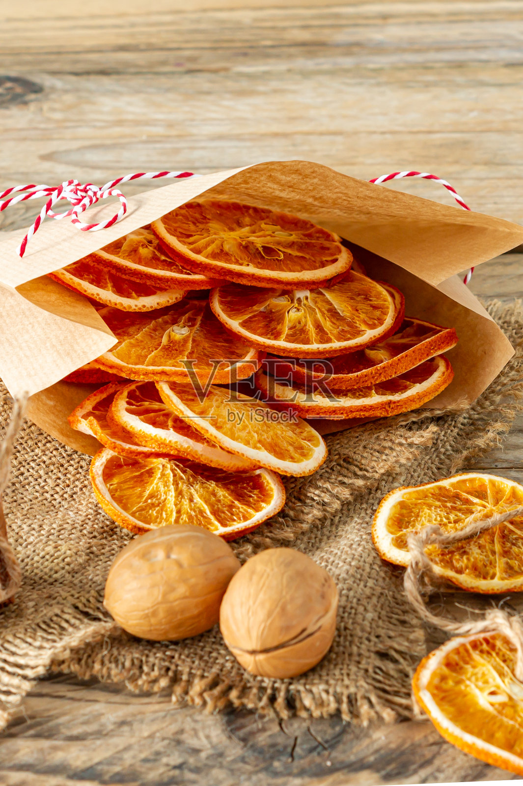 圣诞组成。在木质背景上放置干橙子，肉桂和核桃。乡村，节日香料配料照片摄影图片