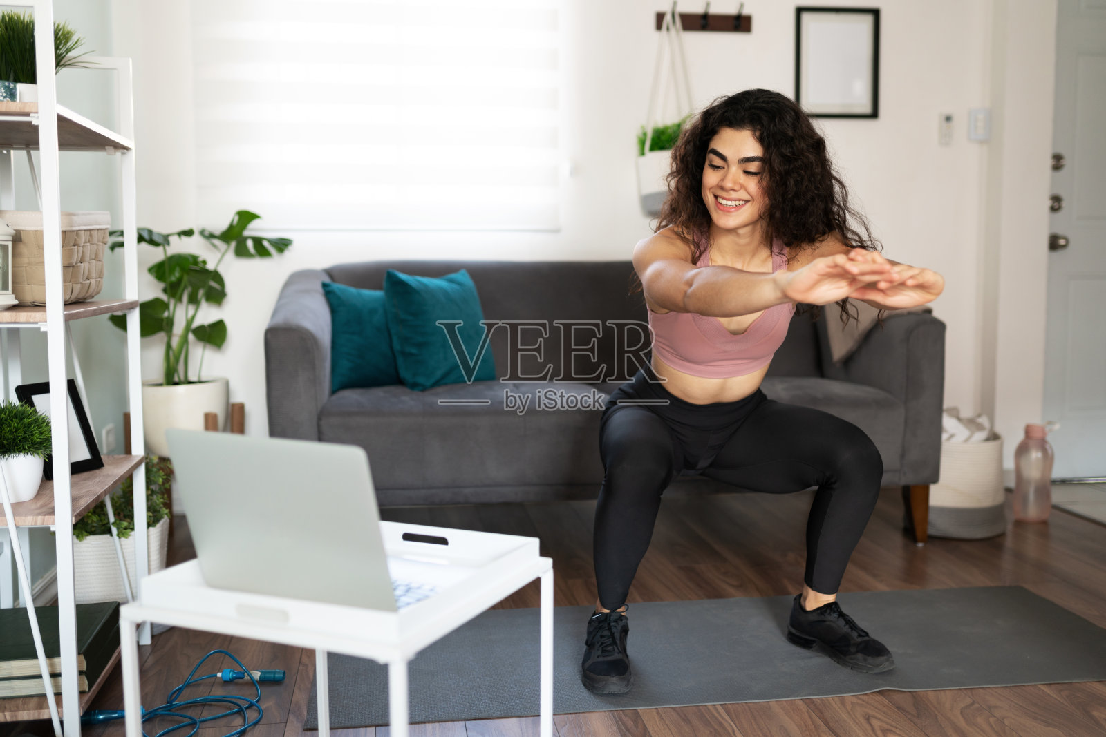 年轻女子微笑着做下蹲练习视频照片摄影图片