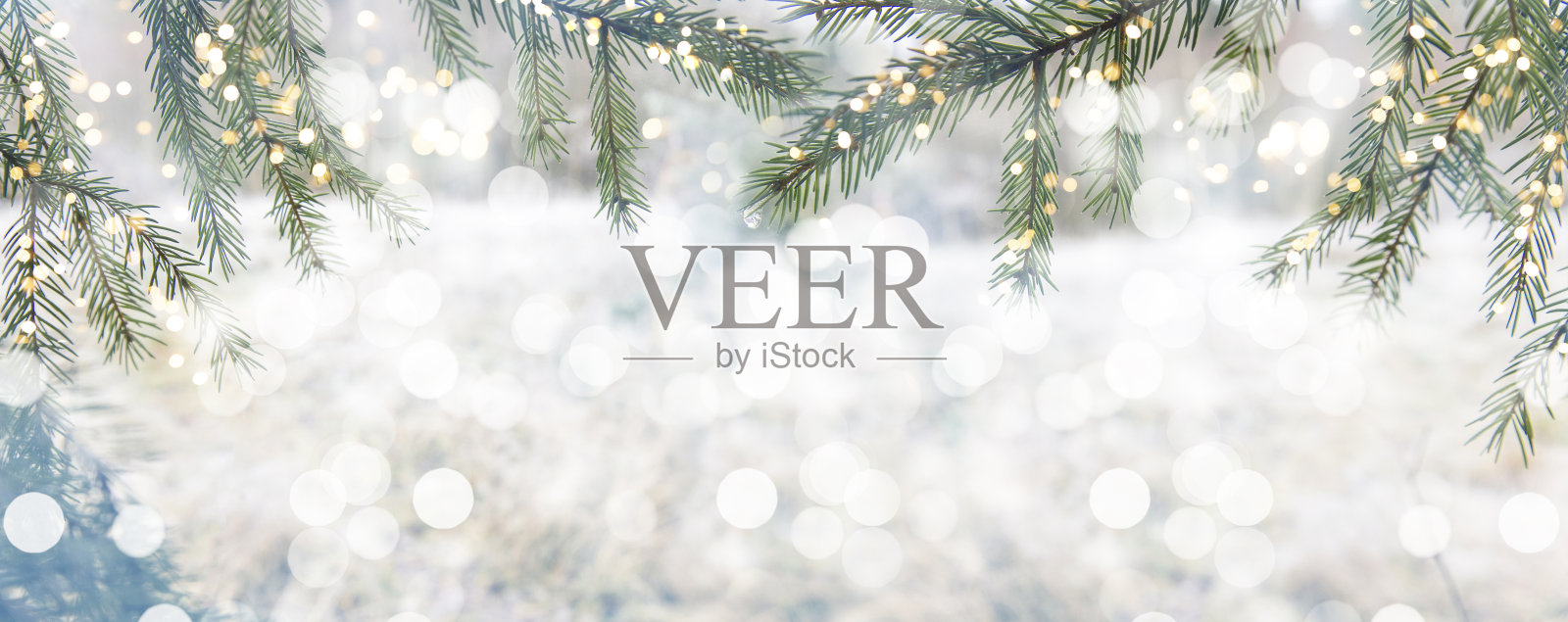 摘要冬季圣诞节的背景有雪、冷杉树枝和彩灯。美丽的柔和大气的自然背景在柔和的浅色。带着柔情散景，选择性聚焦圣诞照片摄影图片