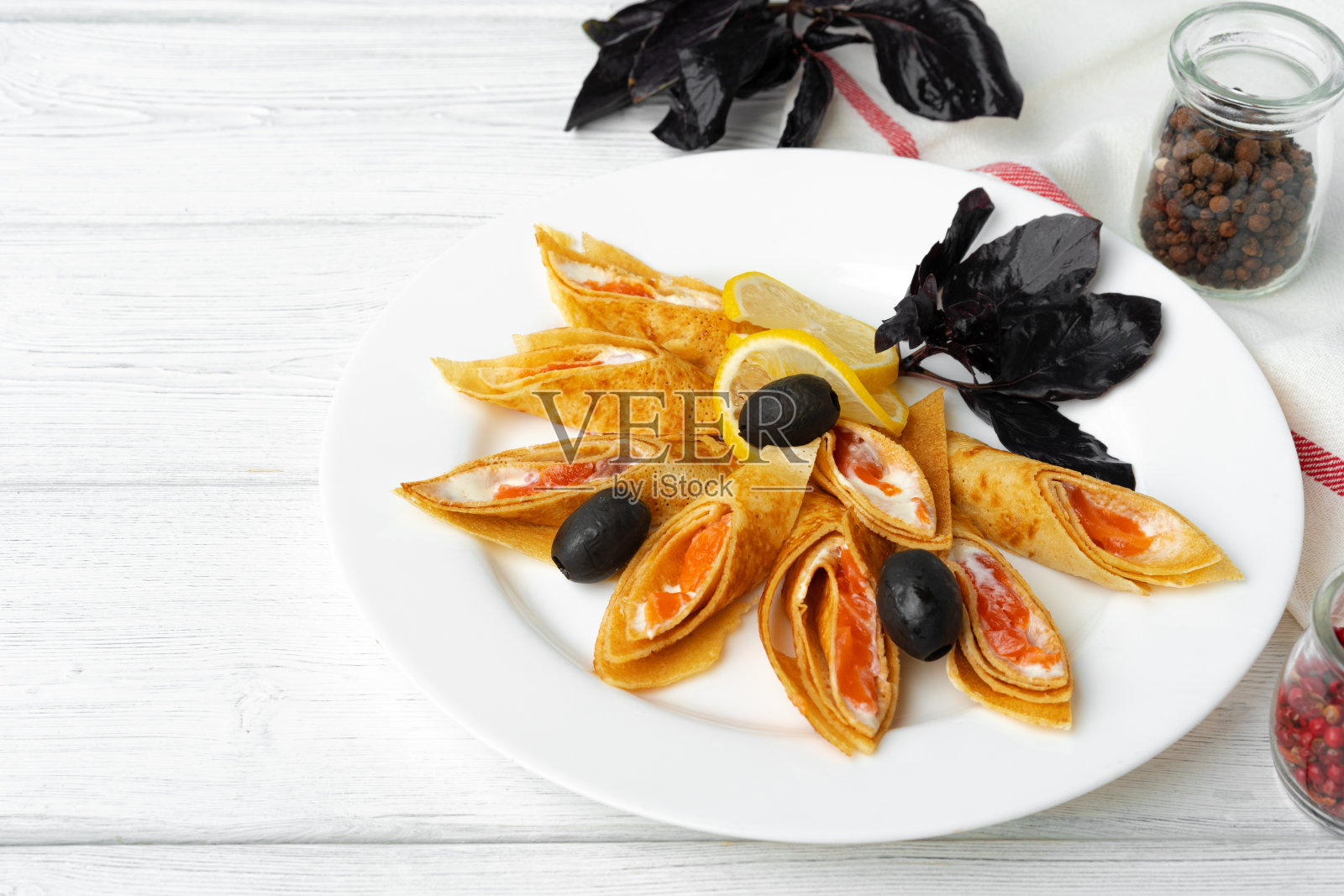 在白色的木制背景上填满咸鱼的俄罗斯煎饼照片摄影图片