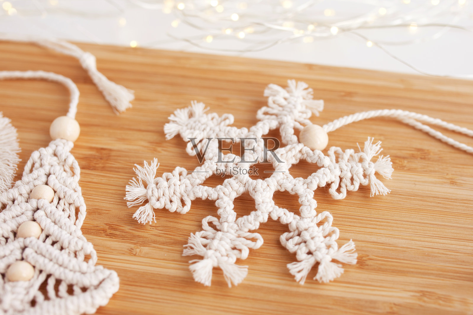 圣诞流苏花边装饰。圣诞雪花的风格macramé。天然材料-棉线，木珠。生态装饰、饰品、手工装饰。寒假和新年假期照片摄影图片