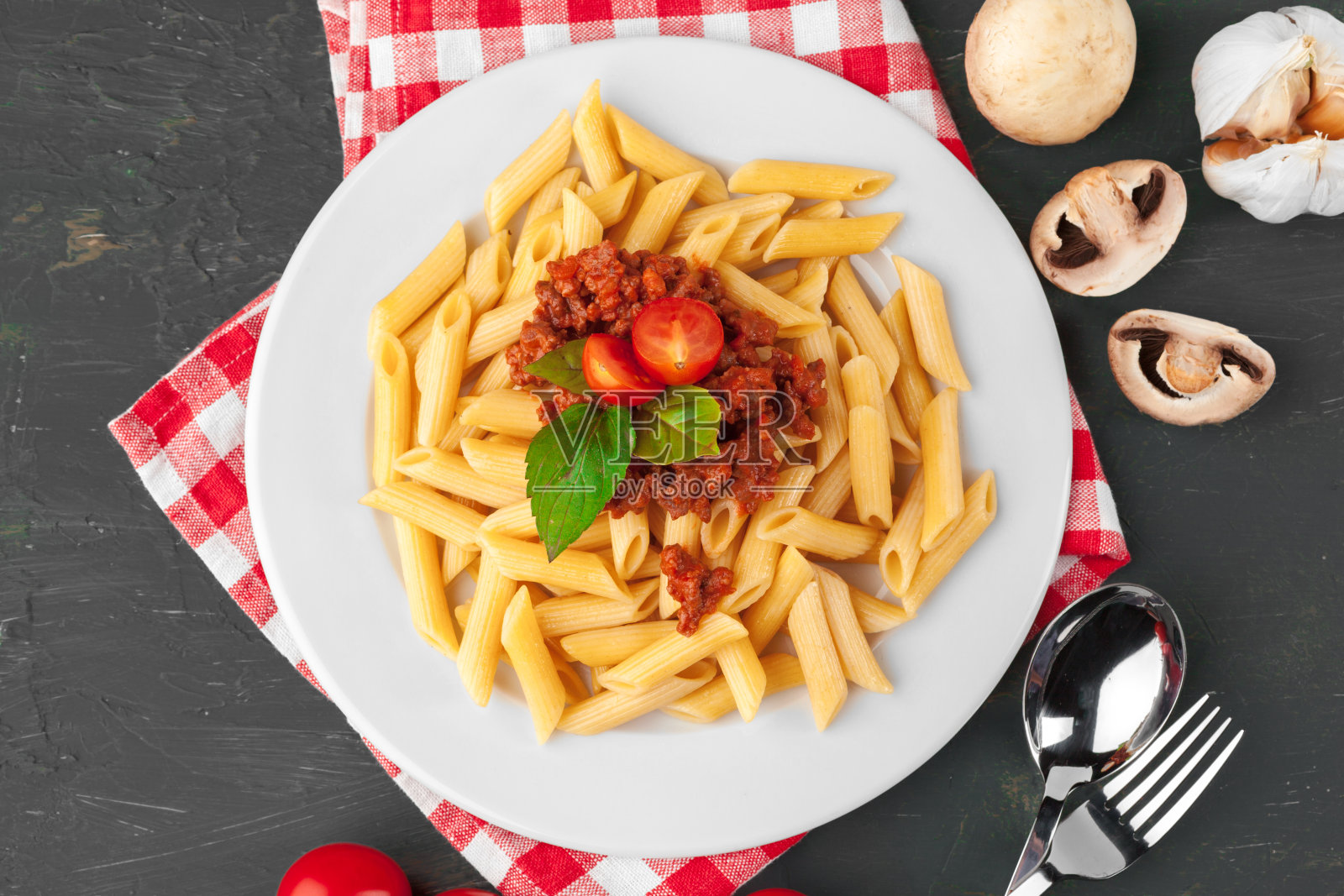 桌上放有肉、番茄酱和蔬菜的意大利面照片摄影图片