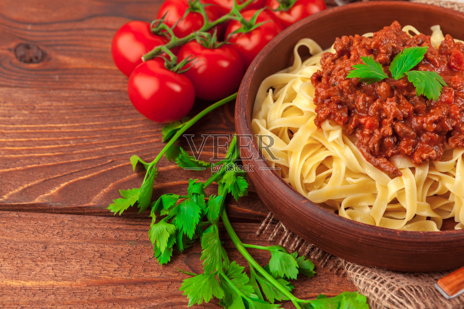 桌上放有肉、番茄酱和蔬菜的意大利面照片摄影图片