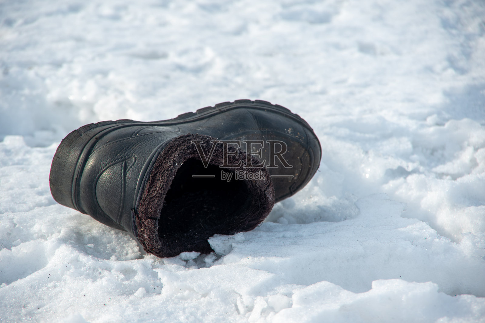 圣诞节节期。旧的破旧的靴子扔在白色的雪地上预示着新娘或新郎将出现的地方照片摄影图片