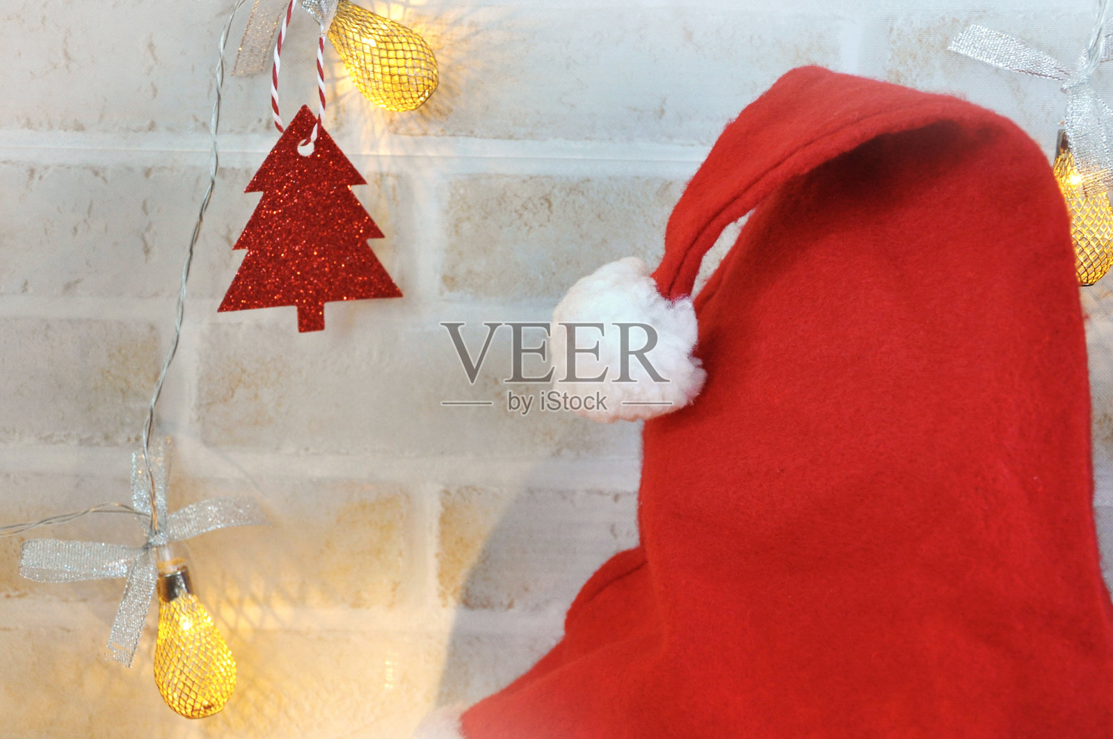 红色圣诞老人帽与墙装饰的背景照片摄影图片