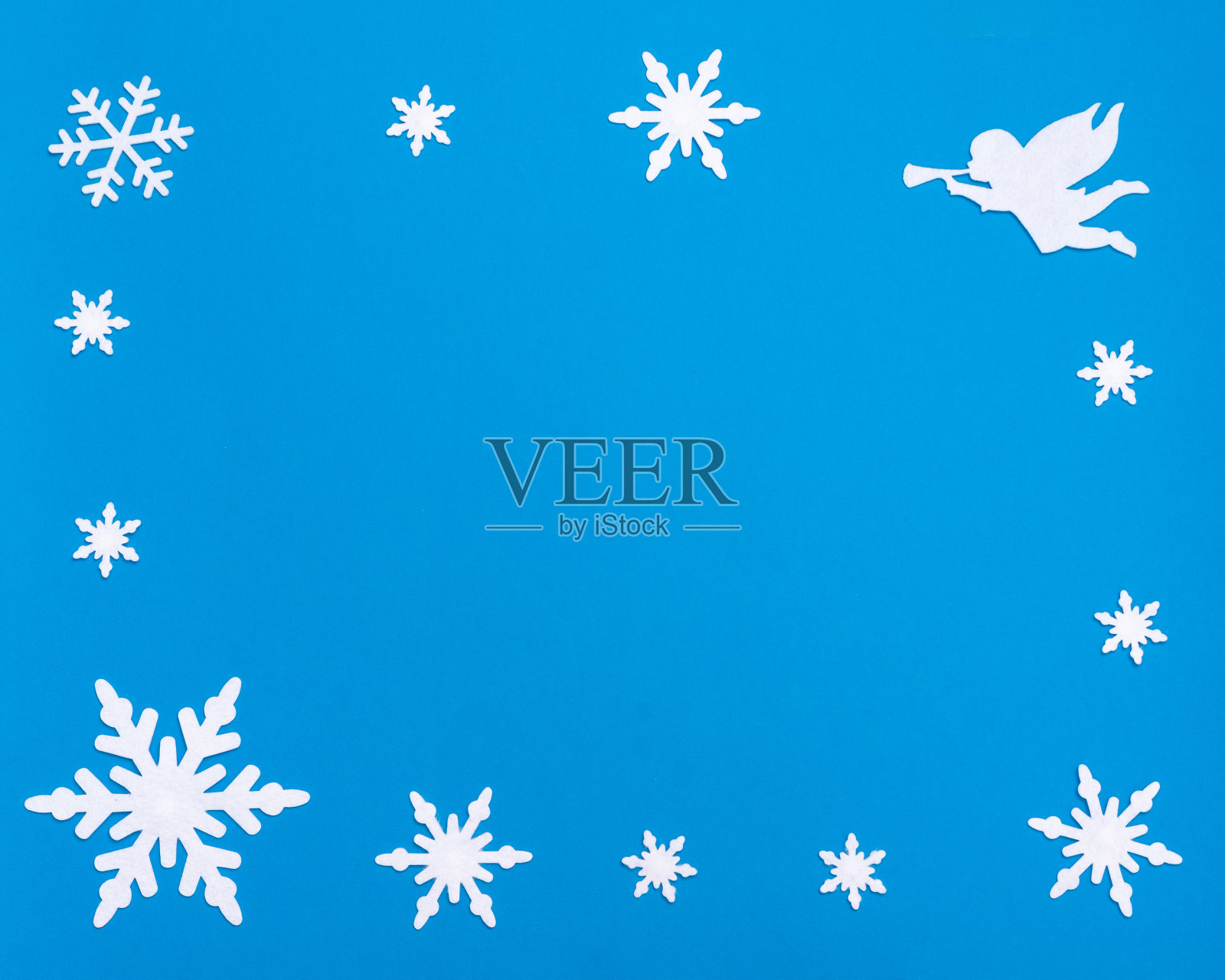 用白色空白的记事本、蓝色的铃铛、白色天使吹的小号和圣诞节的雪花平铺构图照片摄影图片