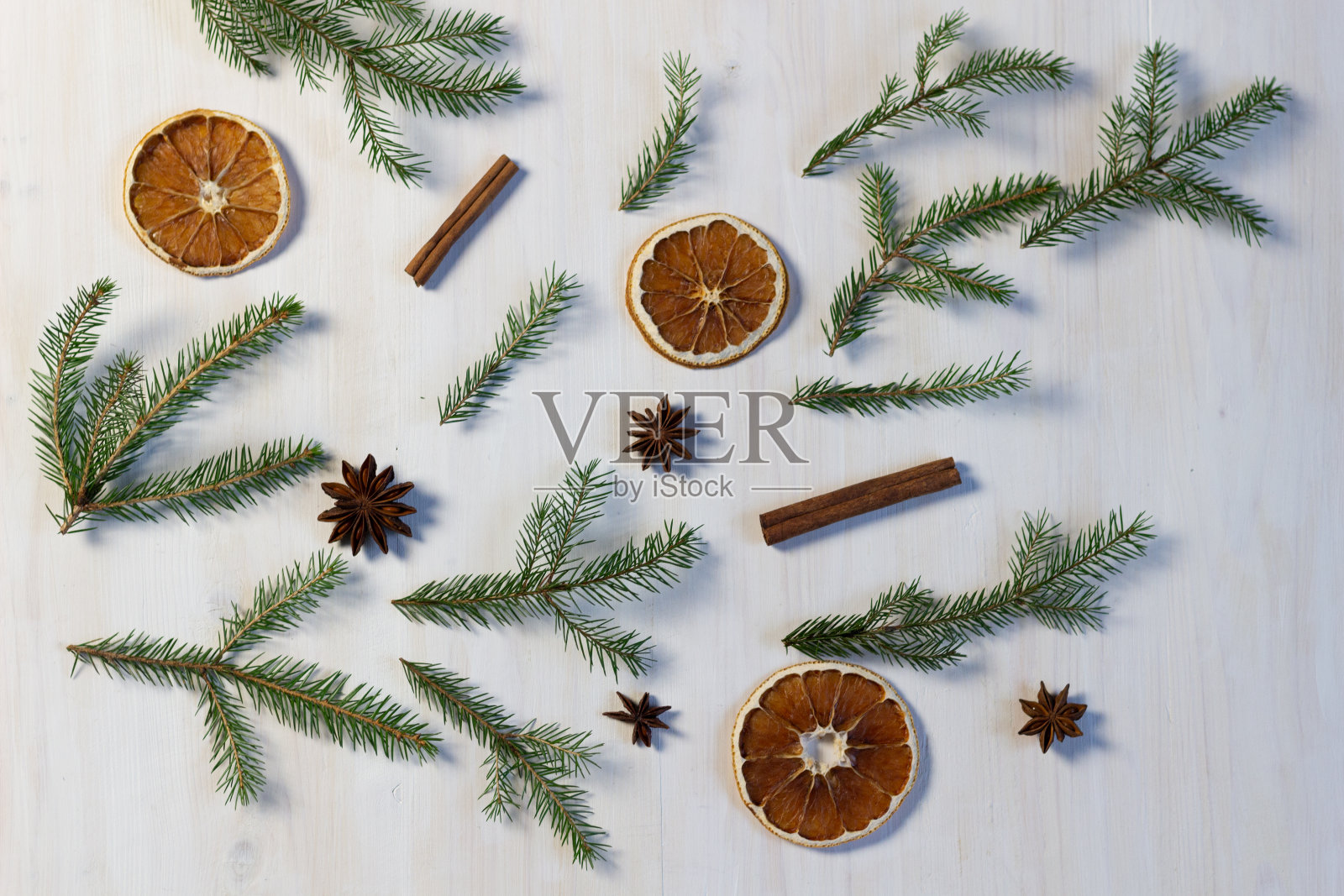 圣诞背景以冷杉树和肉桂棒，anis，干橙装饰白色木质纹理照片摄影图片