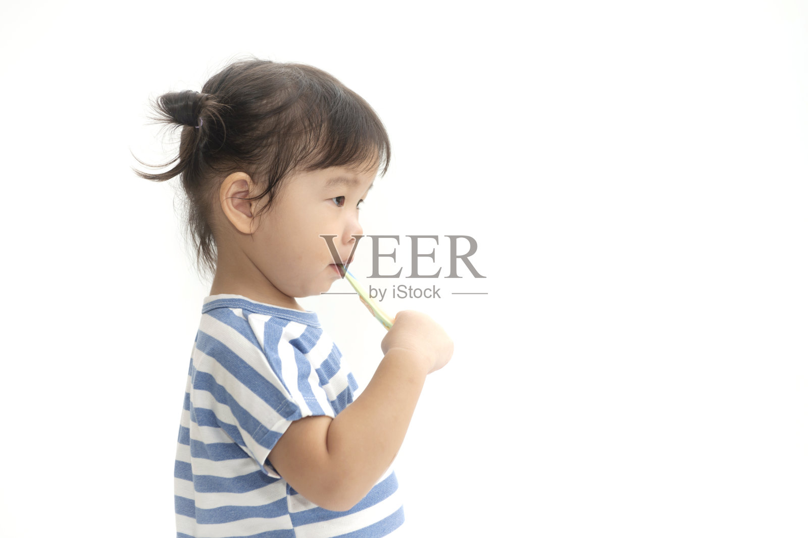 一个可爱的亚洲小女孩刷牙她的牙齿孤立在白色的背景。照片摄影图片