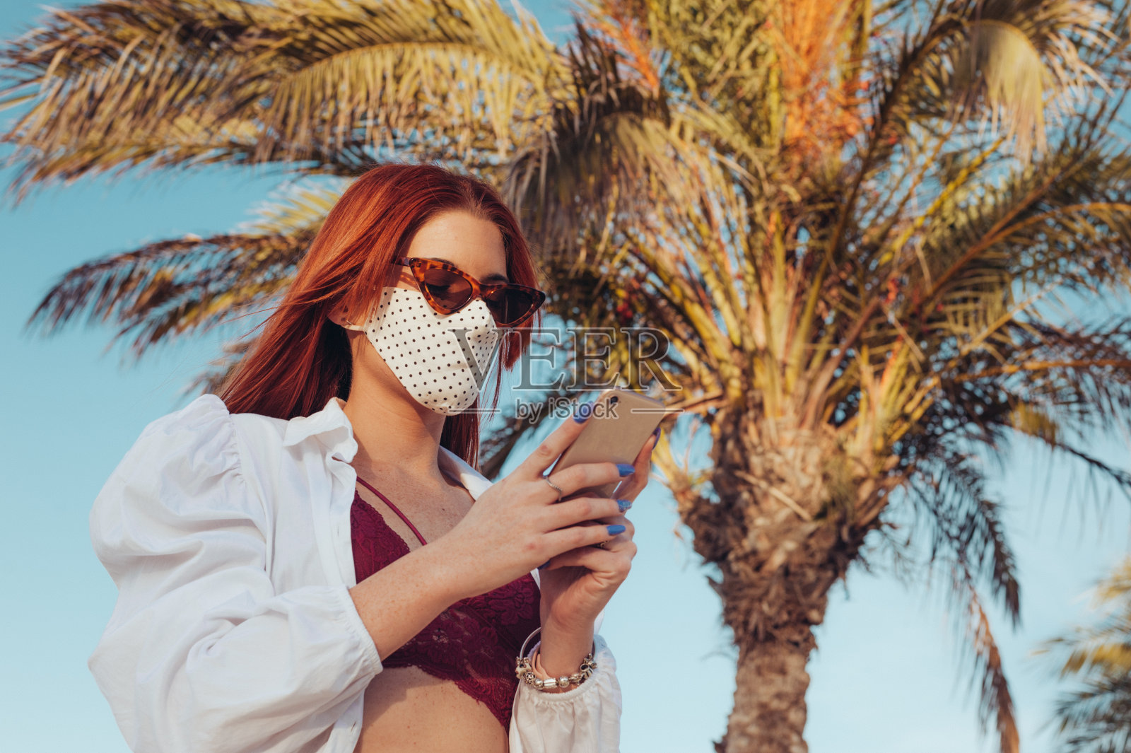 戴着面具打电话的女人照片摄影图片