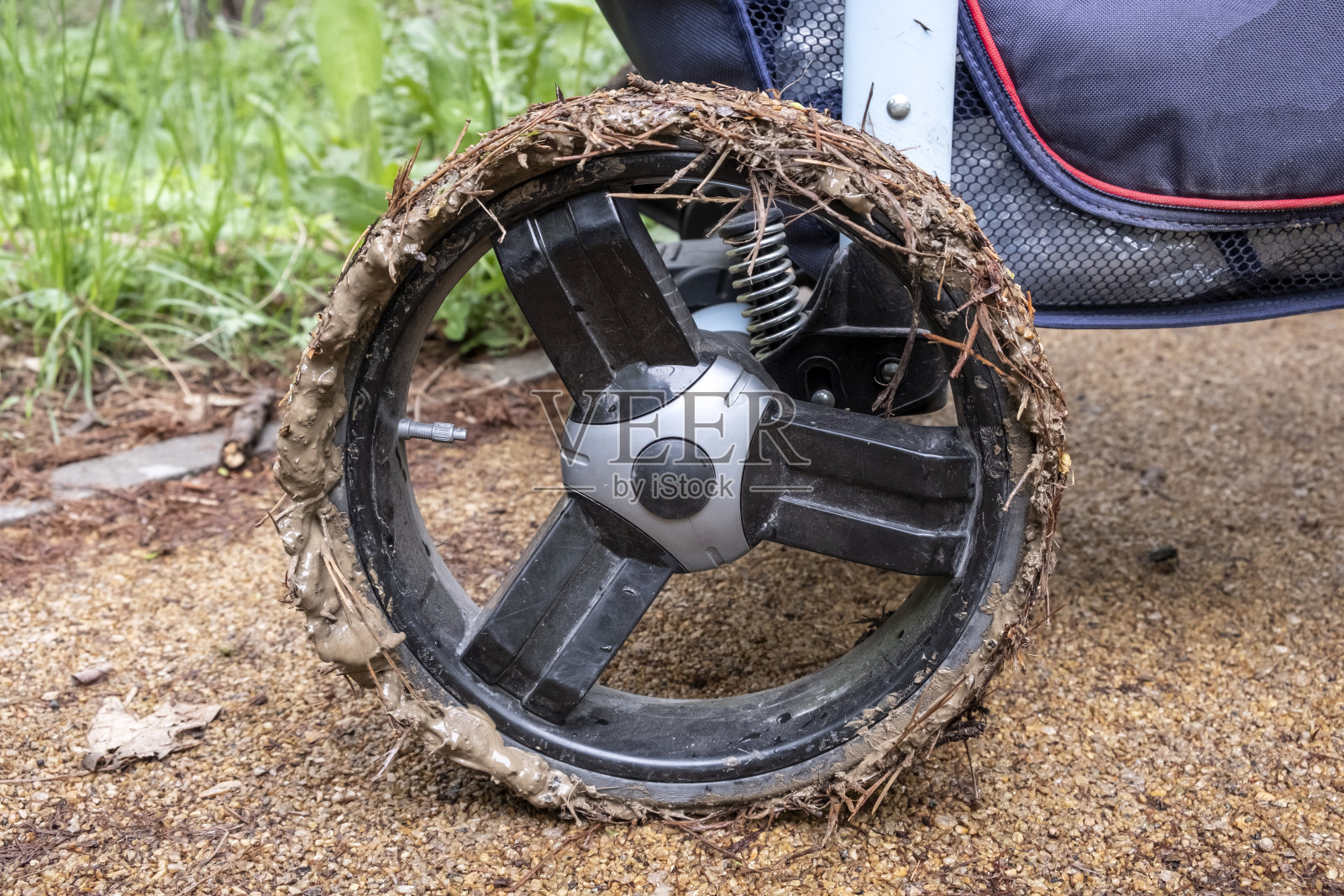 车轮上有泥的婴儿车。行走条件恶劣。照片摄影图片