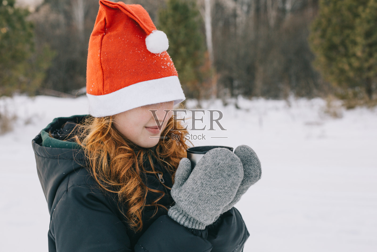 红发女孩戴着圣诞老人的帽子照片摄影图片