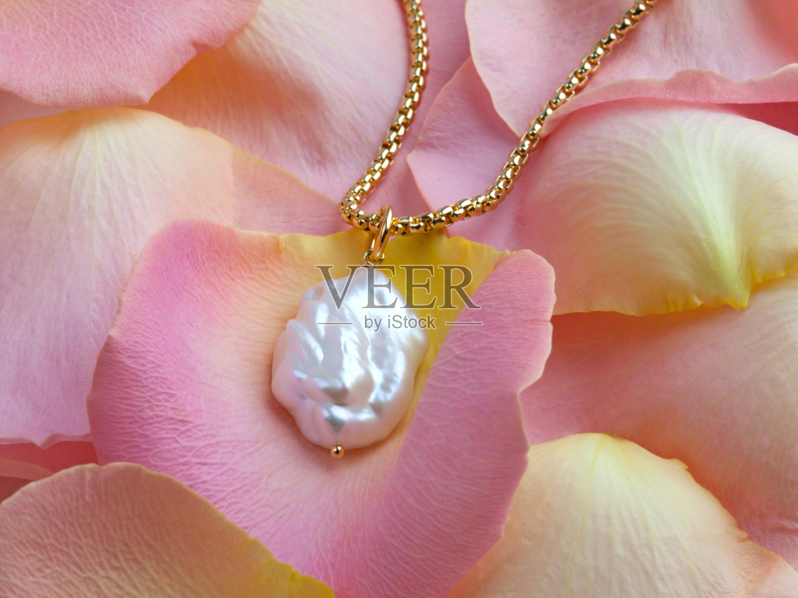 奢华优雅的巴洛克式珍珠吊坠与金链粉红黄色玫瑰花瓣照片摄影图片