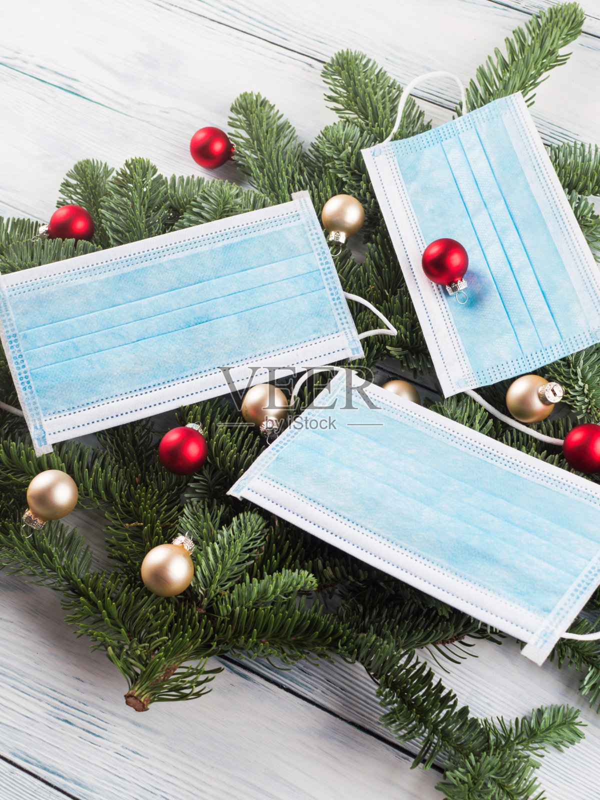 木制桌子上的迷你圣诞树，还有面具照片摄影图片