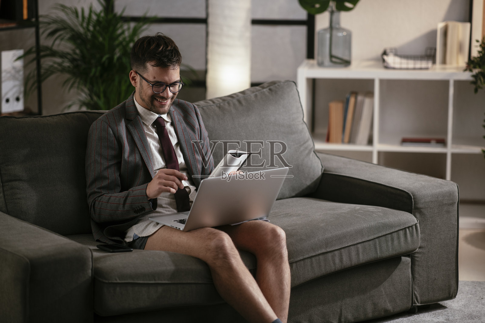 没穿裤子在家工作的商人。照片摄影图片