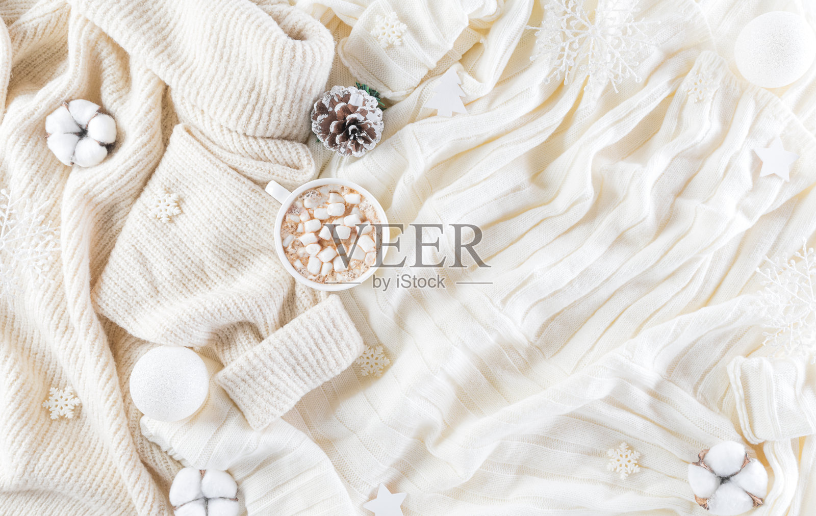 冬季舒适的背景杯咖啡，暖和的毛衣，礼盒，棉花花和圣诞球的羊毛地毯背景，顶视图与复制空间。照片摄影图片