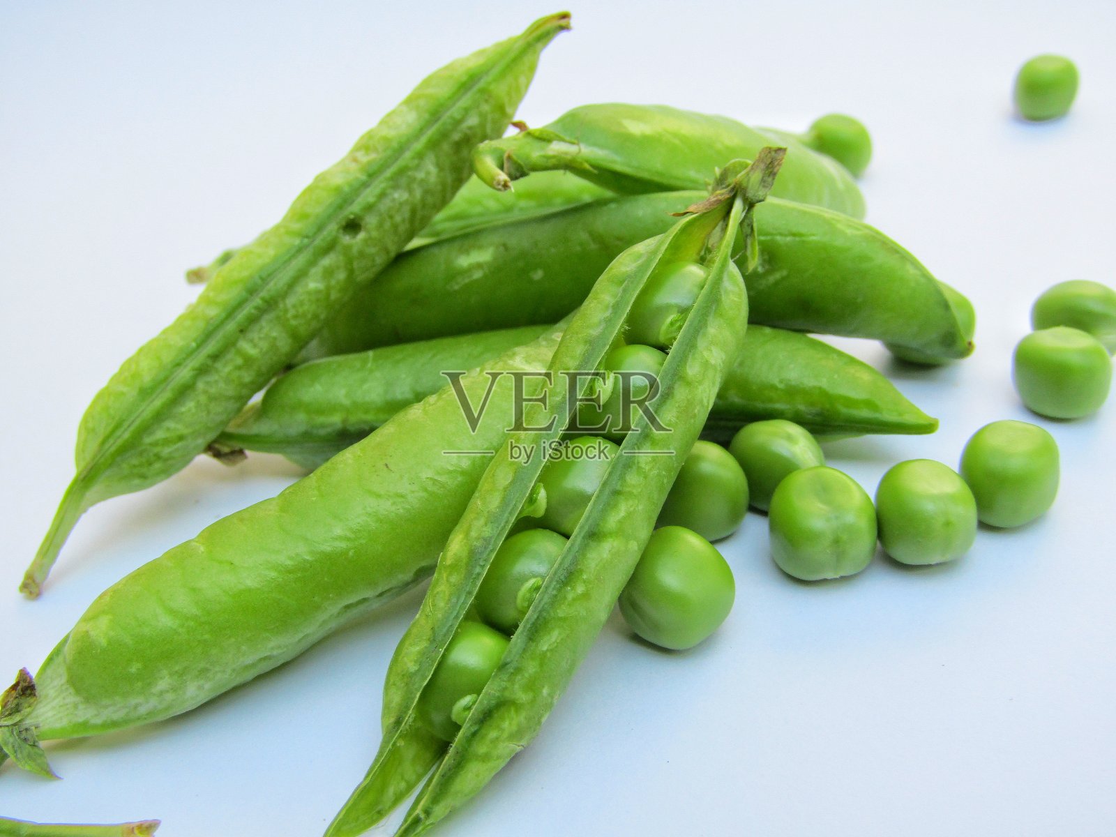 白色背景上的新鲜绿豌豆照片摄影图片