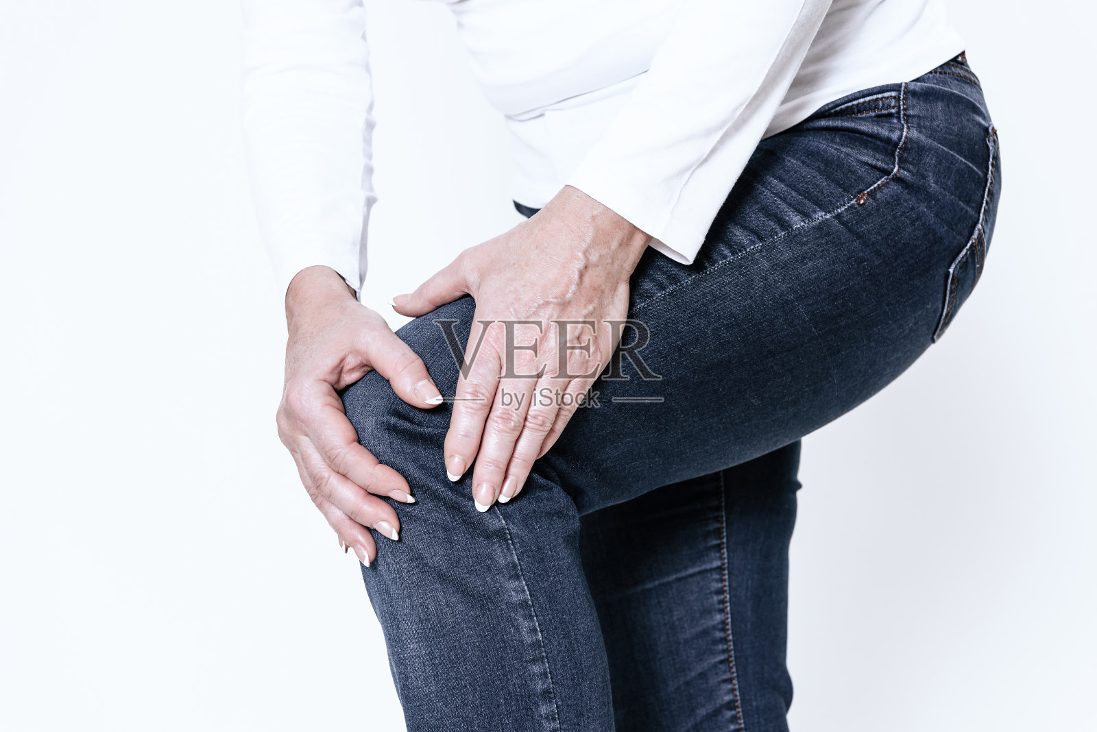 一个女人膝盖疼，她正在做按摩。照片摄影图片