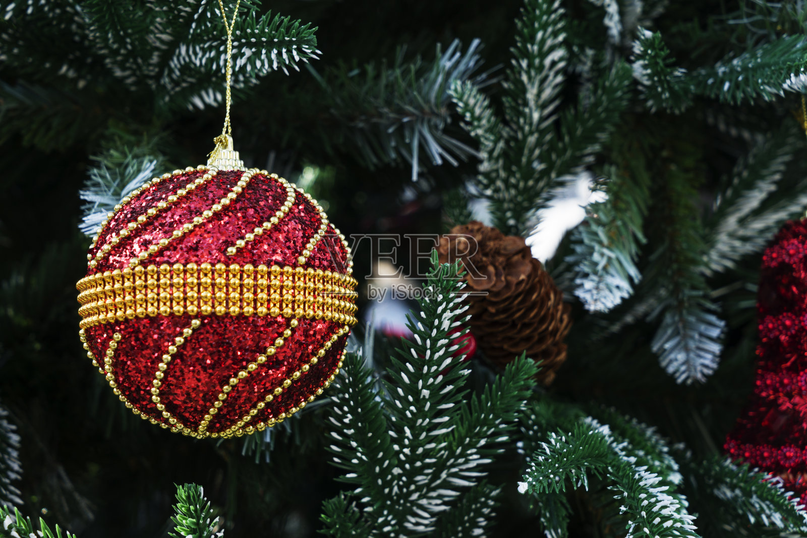 近距离的圣诞树装饰品，雪花，泰迪熊，姜饼屋，松果和灯。照片摄影图片