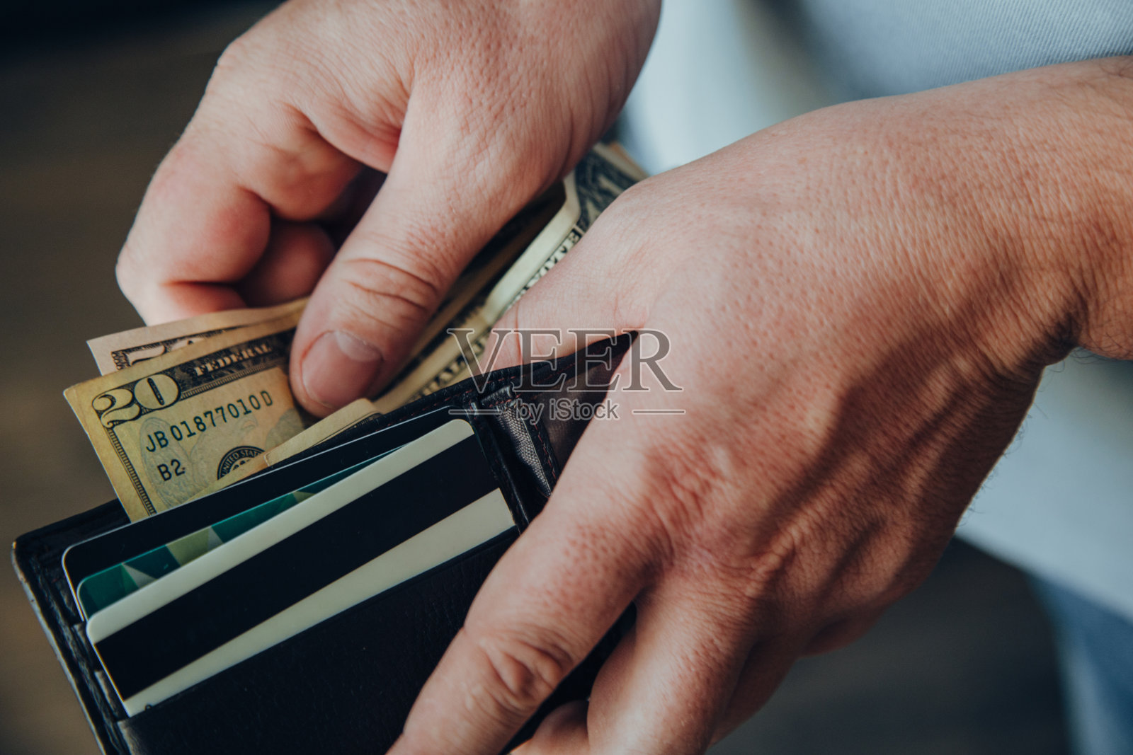 一个在空钱包里数钞票的工人的手。贫困的概念。解雇或积累资金，提取银行存款。金融危机。照片摄影图片