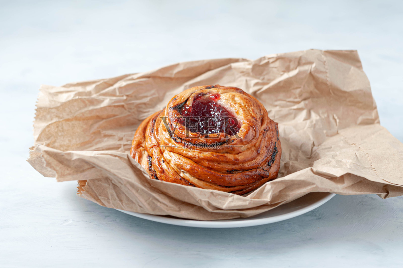 美味酥脆的自制小圆面包配红樱桃甜果酱在手工烹饪纸上装盘照片摄影图片
