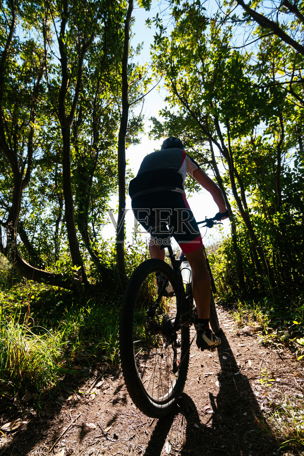 一个骑山地车的无名男子。照片摄影图片