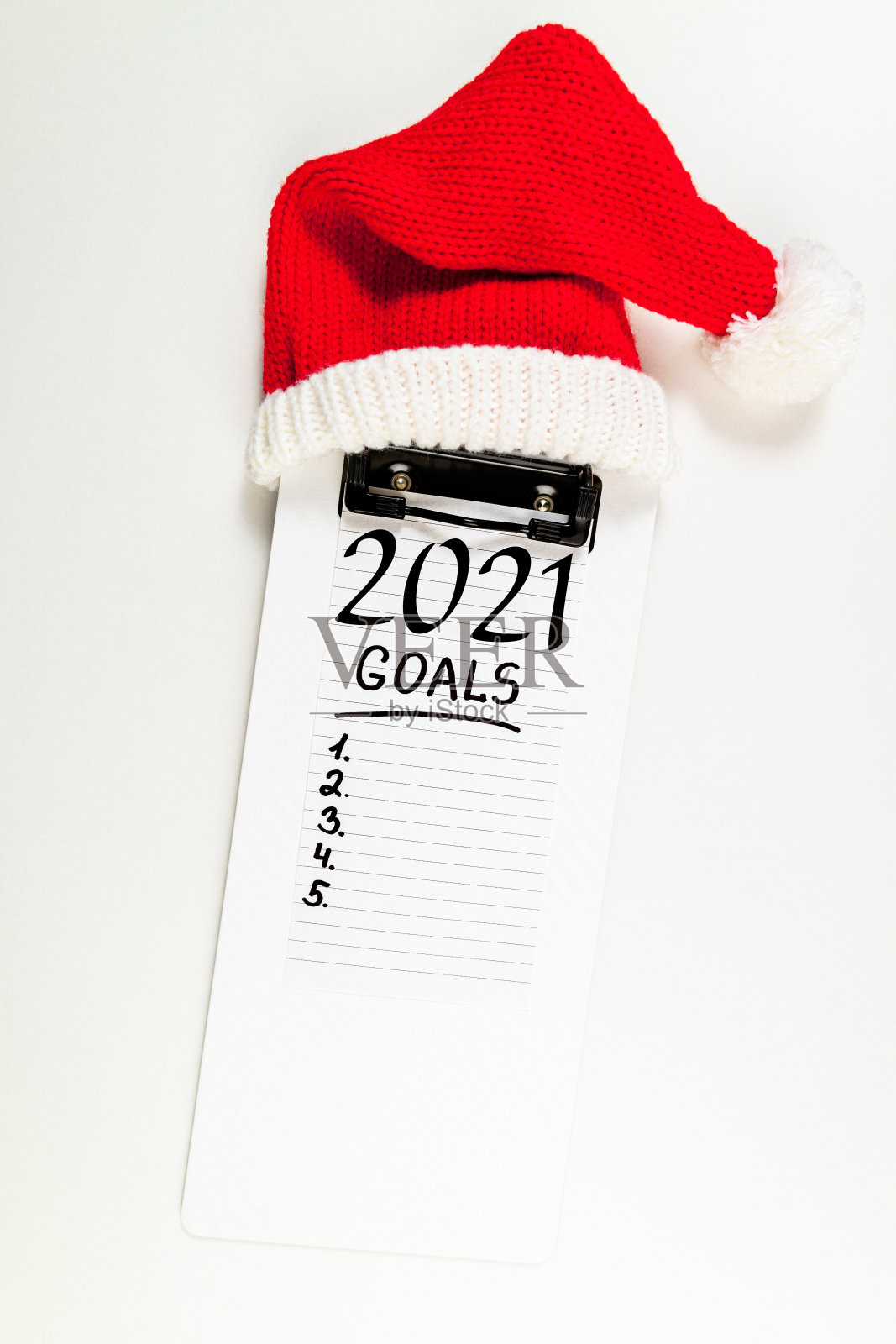 办公桌上的2021年新年目标。白色背景下笔记本和圣诞帽的2021年决心目标，计划，策略，改变，想法概念照片摄影图片