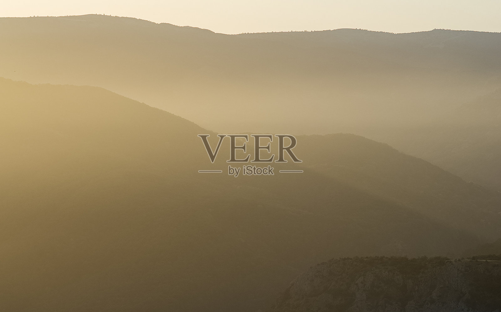 黎明时分，克里米亚的群山。山上的薄雾和透过云层的阳光。照片摄影图片