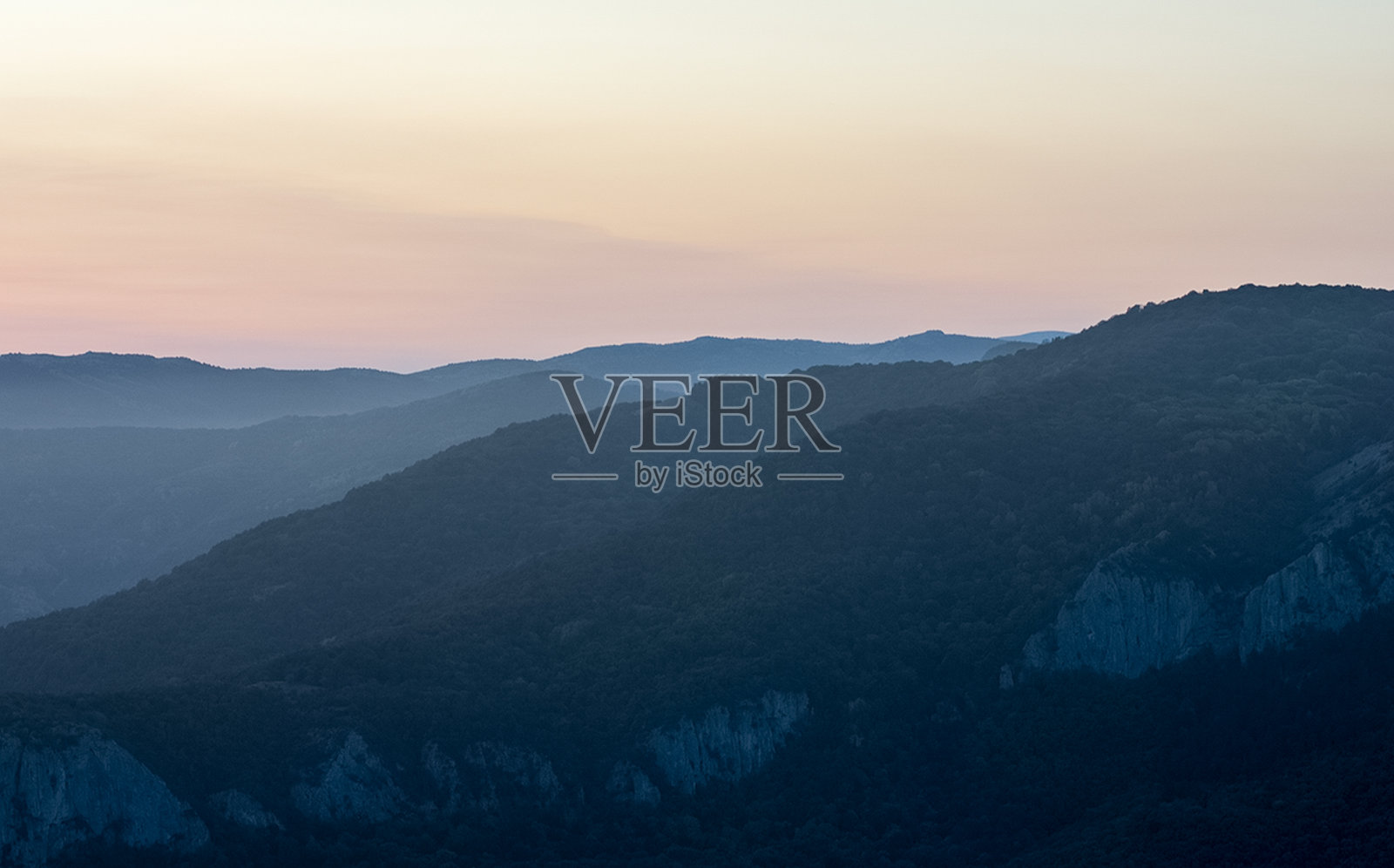黎明时分，克里米亚的群山。山上的薄雾和透过云层的阳光。照片摄影图片