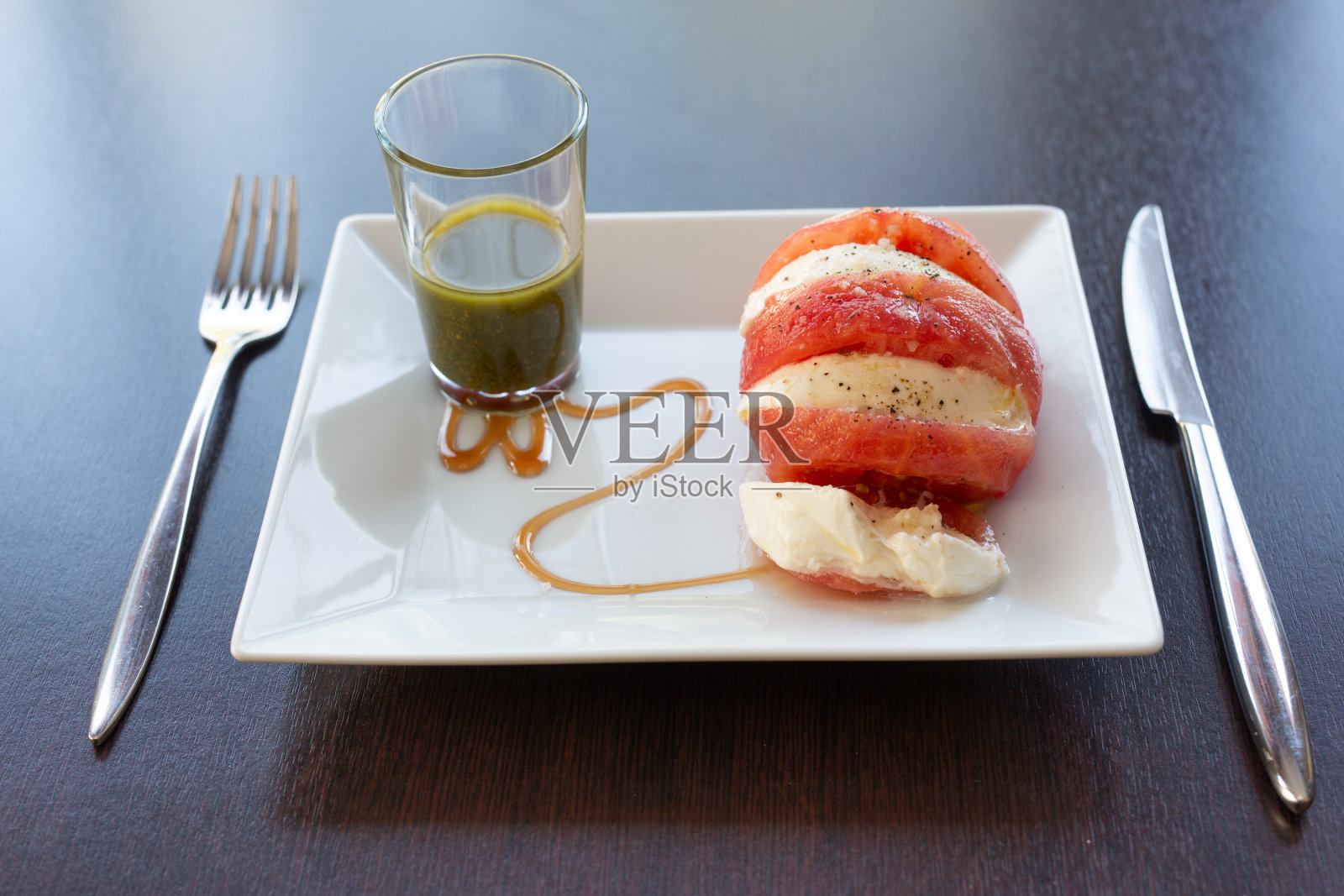 白色盘子，配上马苏里拉番茄照片摄影图片