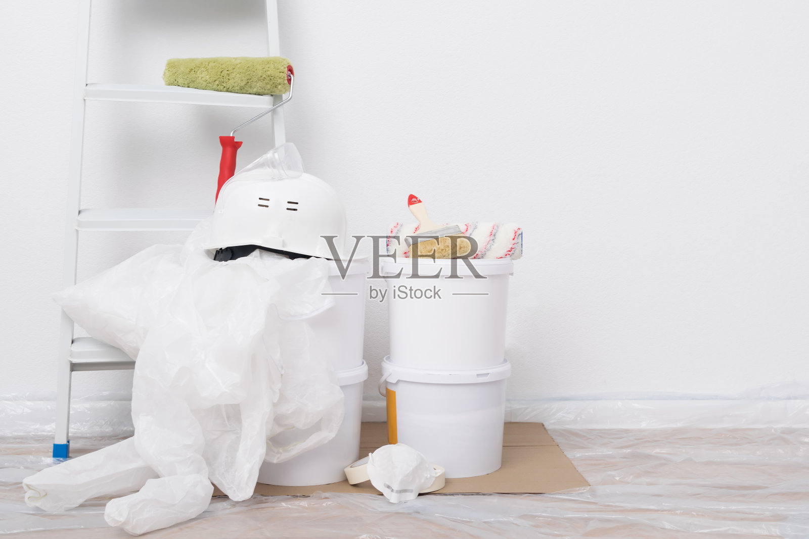 墙壁上的油漆和工具靠在干净的白色墙壁上，上面有一个地方刻字照片摄影图片