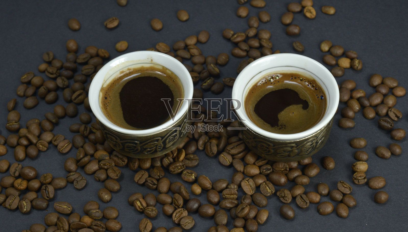 传统阿拉伯咖啡杯，旁边是散装咖啡豆照片摄影图片