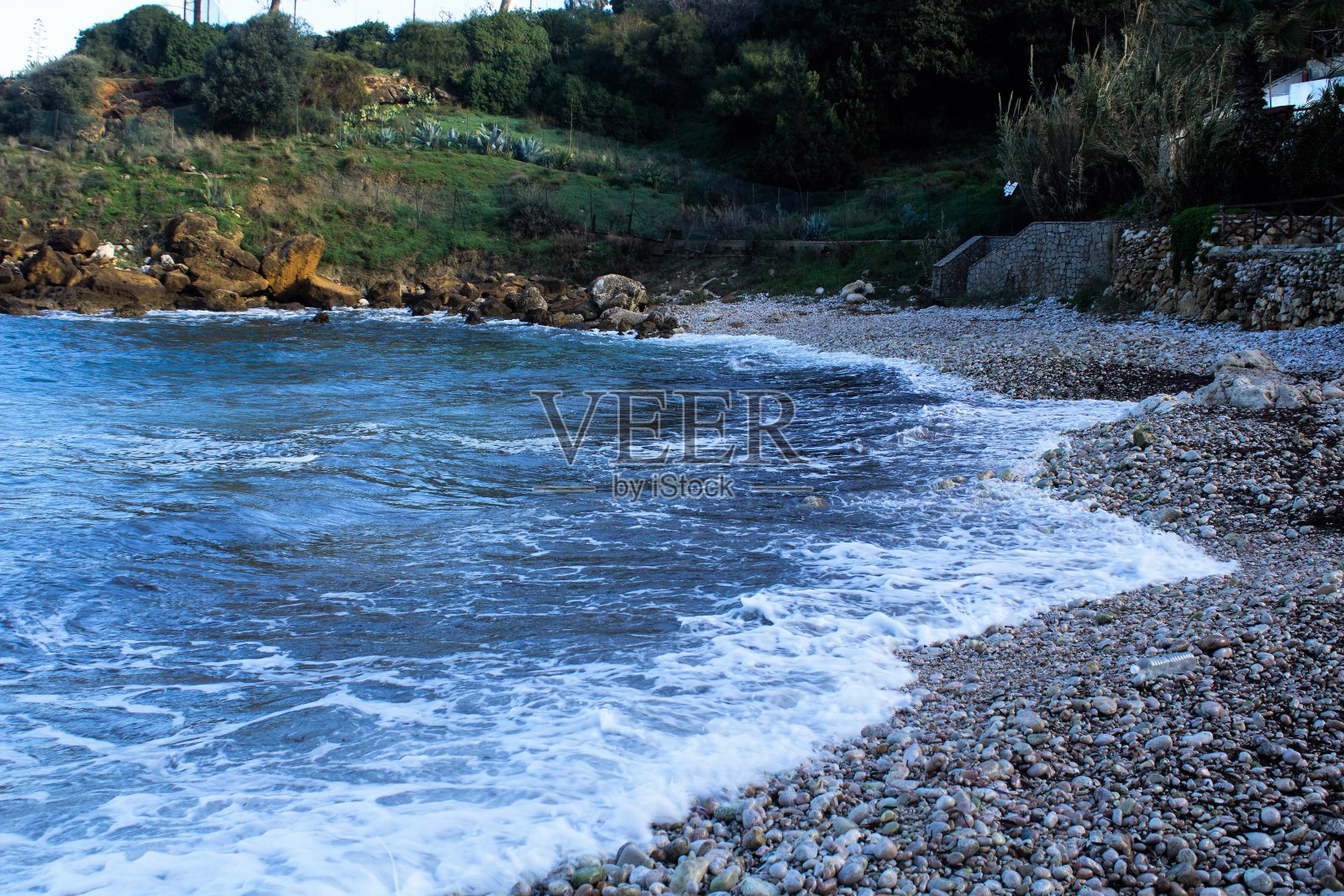 卵石滩与汹涌的大海照片摄影图片