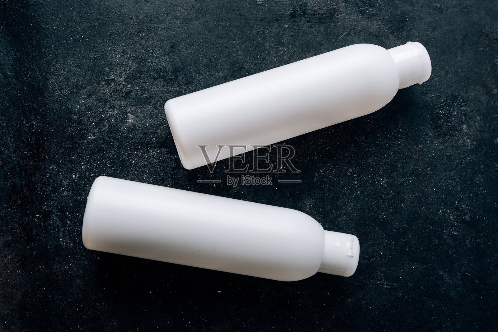 白色的瓶子，黑色的表面，美容和健康的物品照片摄影图片