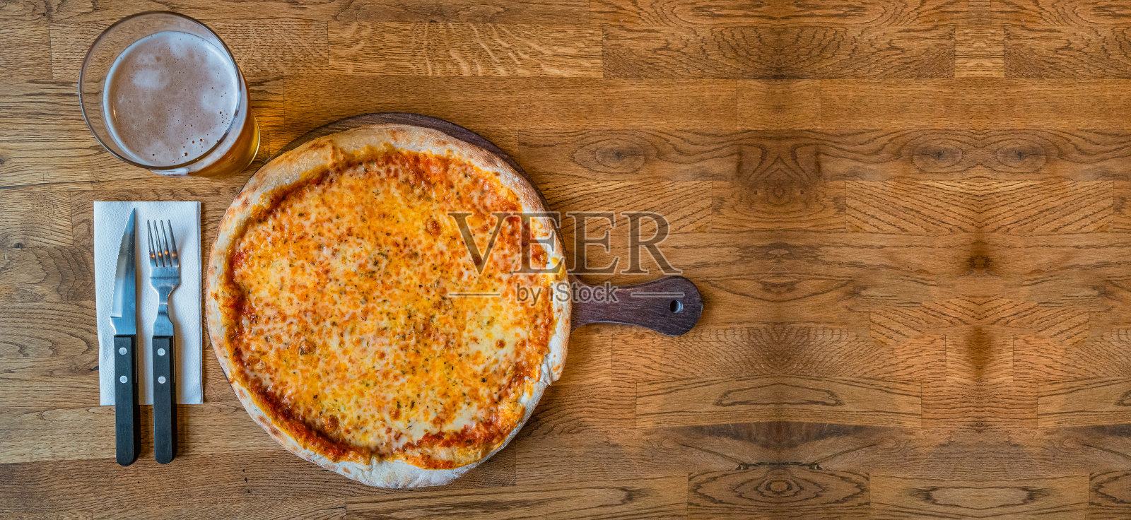 横幅上有美味和开胃的新鲜烤玛格丽塔披萨奶酪和番茄，啤酒杯和叉子和刀与木制背景的复制空间文本，细节，特写。照片摄影图片