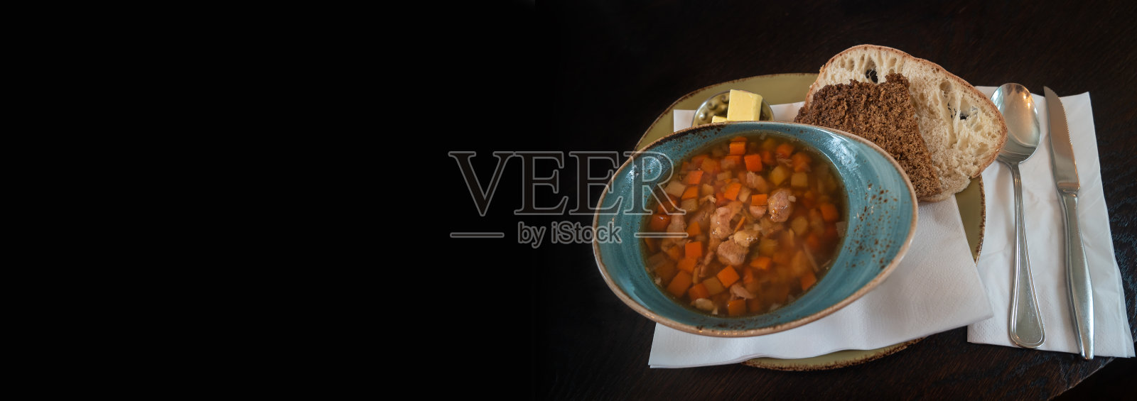 旗帜与传统的冰岛和斯堪的纳维亚羊肉汤，白和黑面包，黄油，勺子在黑色背景与文本复制空间。照片摄影图片