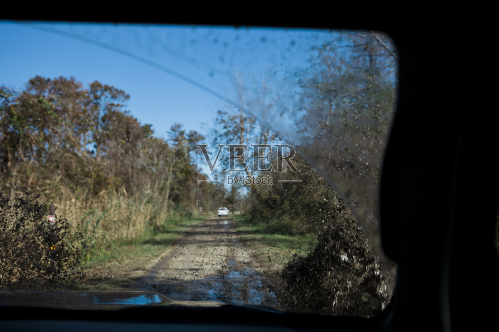 开车穿过溅在挡风玻璃上的泥浆照片摄影图片