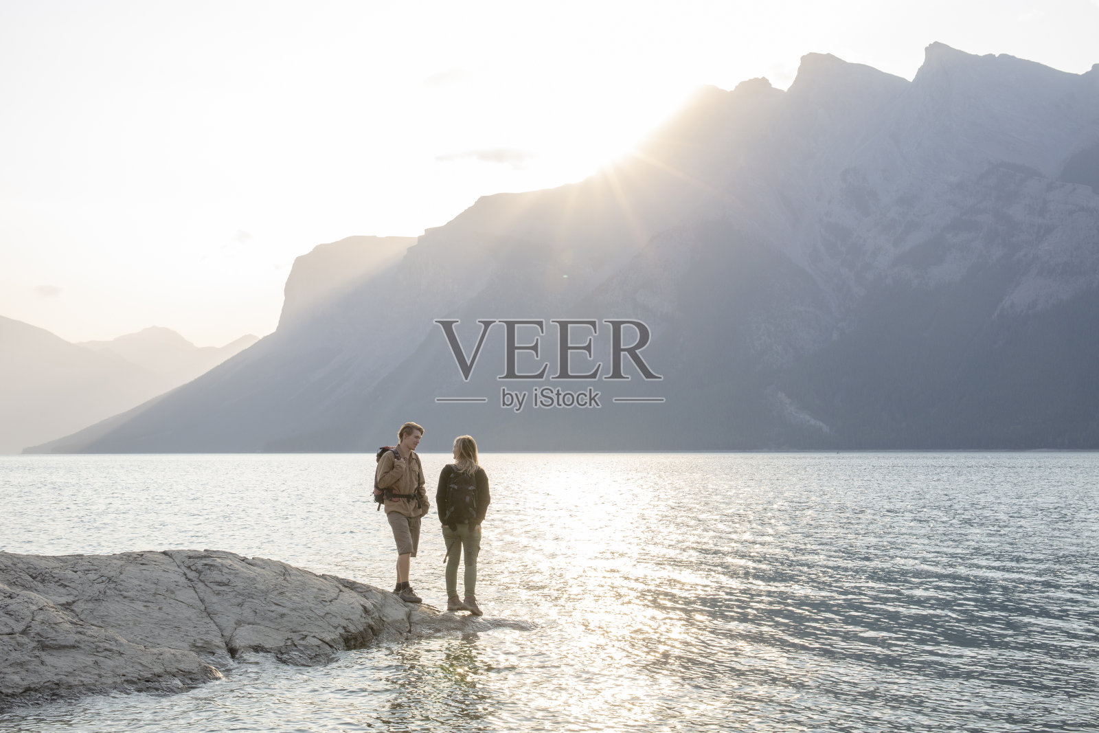 早晨，一对成熟的夫妇在湖边放松照片摄影图片