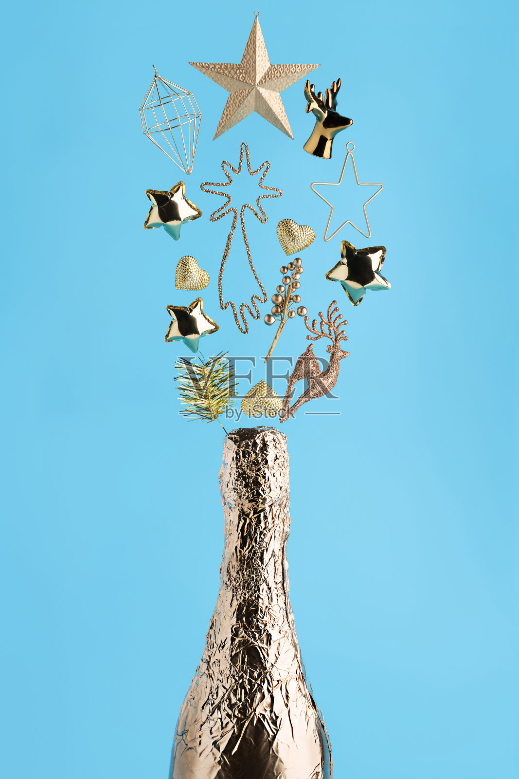 闪亮的金色香槟瓶与爆炸鹿，金色的五彩星星和装饰品照片摄影图片