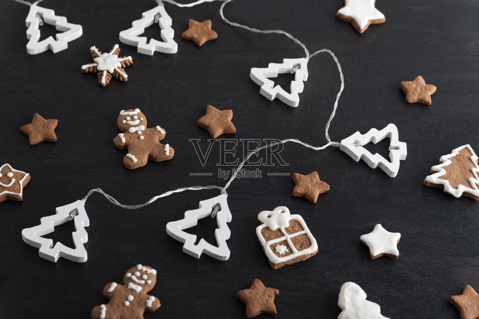 圣诞姜饼人，星星和冷杉树在黑色的背景。俯视图照片摄影图片